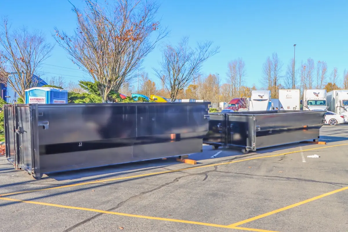 Professional dumpster rental service with roll-off container on residential driveway in Ward